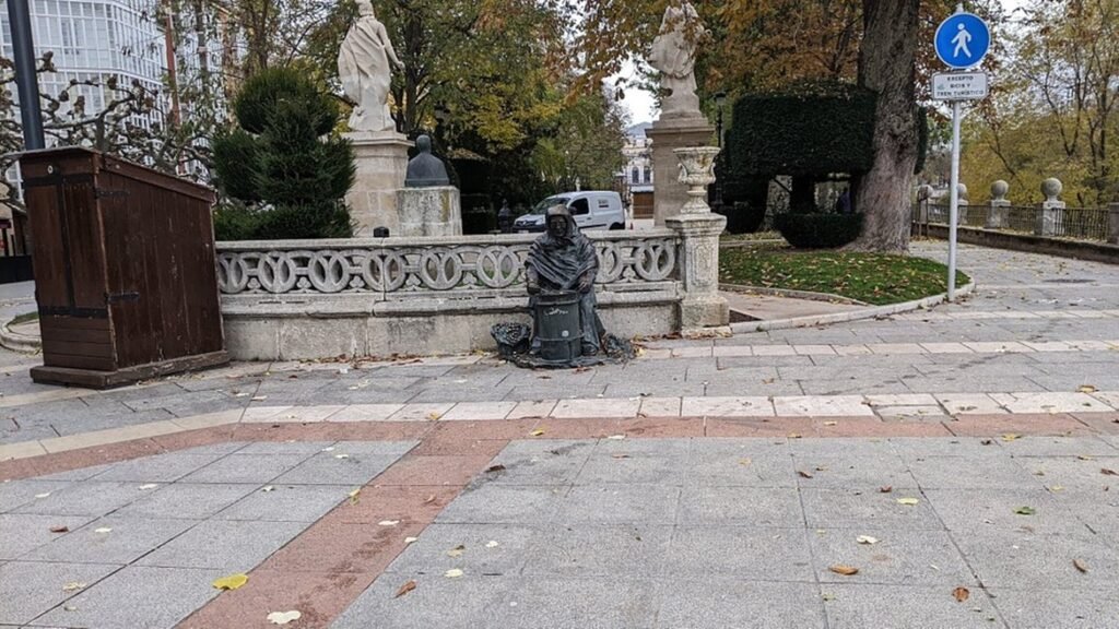 Estatua de la castañera en Burgos junto a un puesto de venta de castañas